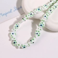 Detail of fish-shaped ceramic beads with green dots and blue evil eye patterns - White Fish With Green Dots (No. 1)