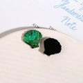 Détail macro d'accessoires en résine en forme de coquillage avec texture irisée - Vert clair