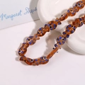 Macro shot of amber glass fish beads with blue dots for DIY jewelry making - Amber Fish With Blue Dots (No. 12)