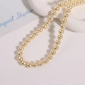 Vue détaillée des perles d'imitation rondes de 10mm crème sur un plateau en céramique - 1 Pièce / Jaune foncé