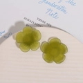 Close-up of grass green resin flower charms with matte finish on a white plate - Green
