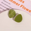 Macro view of olive green resin earrings with irregular geometric shapes and glossy finish - Green