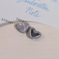 Close-up of heart-shaped DIY fabric buttons with silver silk and mirror finish on a ceramic tray - Silver