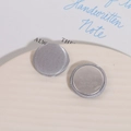 Close-up of elegant silver-gray silk fabric buttons with polished metal back on ceramic plate - Silver Satin (D02—4—14) / Silver