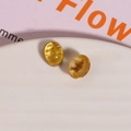 Macro detail of oval amber-toned resin cabochons with gold glitter on white plate - 1 Piece / Yellow