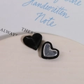 Detailed macro view of heart-shaped fabric buttons with silver metallic centers - Black