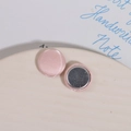 Dettaglio di bottoni magnetici in tessuto rosa a cuore su un piatto di ceramica - Rosa