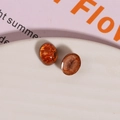 Macro detail of oval amber resin cabochons with gold foil texture for DIY jewelry making - 1 Piece / Orange Brown