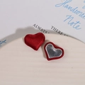 Detail of red and silver heart fabric charms on a white plate for DIY jewelry making - Red