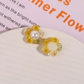 Detailed macro of flower-shaped resin charms with yellow dried petals and white pearl center - Yellow