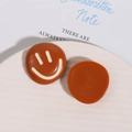 Dettaglio di ciondoli a sorriso in resina marrone per decorazioni fai-da-te e cover - Marrone