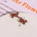 Close-up of translucent brown glass butterfly beads with silver eye pin for DIY jewelry - Transparent with Red Thread