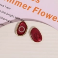 Detail of red enamel oval earrings with gold edges and pearl accents on ceramic tray - Pearl Circle