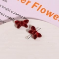 Macro detail of red glass bow-knot charms for DIY jewelry making and earrings - Red with Red Thread