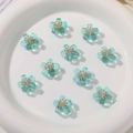 Macro view of blue translucent flower beads with gold centers for DIY jewelry making - 1 Piece / Lake Green