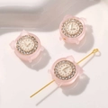 Makroaufnahme einer rosa Harzperle in Weckerform mit Strasssteinen und Lochstruktur - 1 Stück / Hellrosa