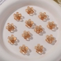 Close-up of translucent amber resin flower charms with golden stamens in a white ceramic bowl - 1 Piece / Light Coffee