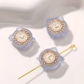 Makro-Detail von mattierten Mini-Wecker-Anhängern mit Strasssteinen für DIY-Schmuck - 1 Stück / Helllila