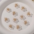 Macro detail of transparent resin flower beads with gold centers on a white ceramic plate - 1 Piece / White