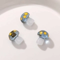 Close-up of translucent blue mushroom resin pendants with yellow dots for DIY jewelry - Blue