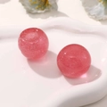 Makroaufnahme glitzernder rosa Harzperlen für DIY-Schlüsselanhänger mit Silberpartikeln - Rosa