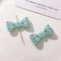 Detail of light blue resin bow beads with colorful polka dots for DIY jewelry making - Lake Blue