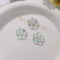 Vue macro de perles fleurs acryliques bleu clair irisées pour la création de bijoux DIY - 1 Pièce / Vert Lac