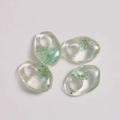 Macro detail of irregular transparent resin pendants with embedded blue dried flowers - Pale Green