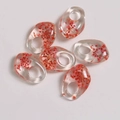 Macro detail of transparent resin charms with pink dried flowers for DIY jewelry making - Dark Orange