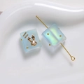 Macro detail of frosted blue resin square beads with gold rabbit and aurora shimmer - 1 Piece / Blue