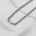 Silver cuban link necklace with oval white shell inlay on a white fabric background - White Mother of Pearl Necklace (DG-XL00195) / Silver