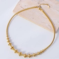 Detail der goldenen geometrischen Kette mit Spindelanhängern auf Marmorstein - Dekorativer Stil mit konischem Verlauf (Bild 2)