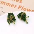 Macro shot of handmade beaded green rice dumpling earrings with gold bow details - Triangular Rice Dumpling Shape (Dark Green)