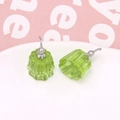 Macro shot of green resin jelly pudding earrings on a white porcelain tray - Green