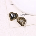 Dettaglio di ciondoli a cuore in oro vintage con strass grigi e cornici floreali - Strass Grigio Cuore