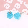 Detail of sky blue jelly resin earrings in pudding shape on white tray with pink backdrop - Blue