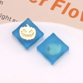 Close-up of blue frosted resin square charms with golden pumpkin for DIY jewelry - Blue