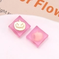 Detail of pink translucent resin square charms with golden Halloween pumpkin motifs - Rose Red