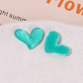 Close-up of heart-shaped glitter resin accessories in teal color for DIY crafts - Green