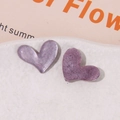 Close-up of purple heart-shaped resin charms with pearlescent glitter texture for DIY crafts - Purple