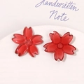 Close-up of translucent red resin cherry blossom charms for DIY jewelry and crafts - Red