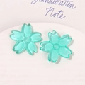 Close-up of translucent teal cherry blossom resin charms for DIY earring and jewelry crafts - Blue