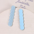 Primer plano de pinzas de resina azul claro onduladas con purpurina y efecto mate - Azul