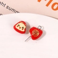Macro shot of red enamel heart charm with gold Fu character and cute round face pendant - Red One Piece