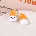Close-up of cute white resin ghost charms with orange hats for DIY jewelry and crafts - Orange