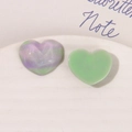 Nahaufnahme von herzförmigen Glitzer-Resin-Charms mit Marmortextur für DIY-Bastelarbeiten - Grün