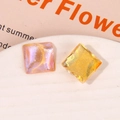 Dettaglio di ciondoli quadrati in resina glitterata con motivi a onde viola e oro - Arancione