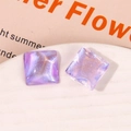 Close-up of square purple resin charms with shimmering cat-eye effect and gold glitter - Purple