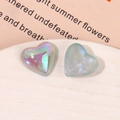 Macro shot of iridescent aurora and glitter resin heart charms for DIY accessories - Iridescent Blue Heart Style