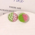 Macro detail of round resin charms with pink and green hammer textured finishes - Green